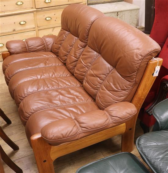 A brown leather two seater Scandinavian sofa